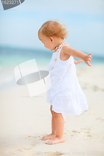 Image of Toddler girl in white dress at beach