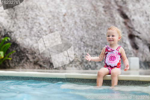 Image of Toddler girl splashing in swimming pool