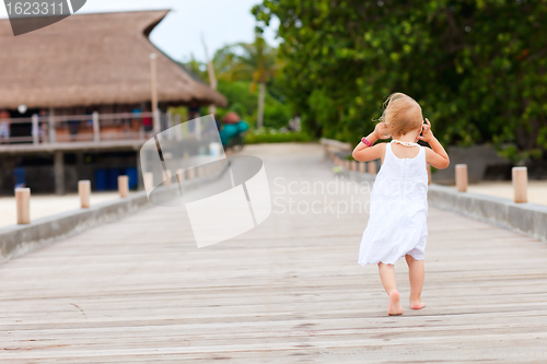 Image of Little girl running on jetty