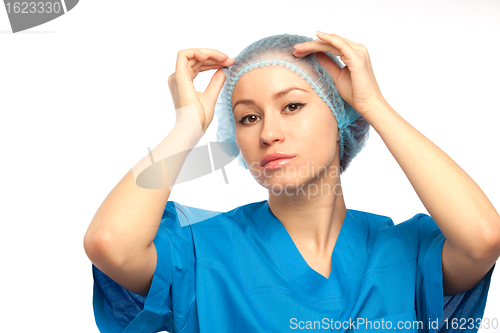 Image of nurse adjusts hat