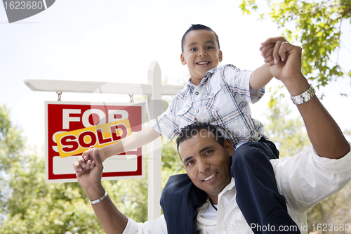 Image of Hispanic Father and Son with Sold Real Estate Sign