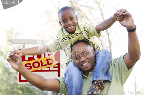 Image of Father and Son In Front of Real Estate Sign