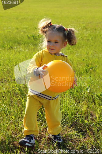 Image of little girl with ball on meadow