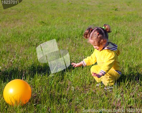 Image of little girl with ball on meadow