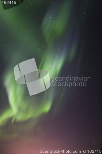 Image of Aurora borealis over town lights glow