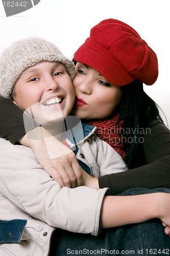 Image of Mother kissing her child on the cheek.