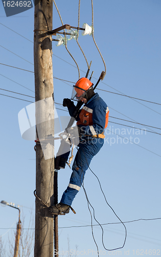 Image of Electrician working at height with wires