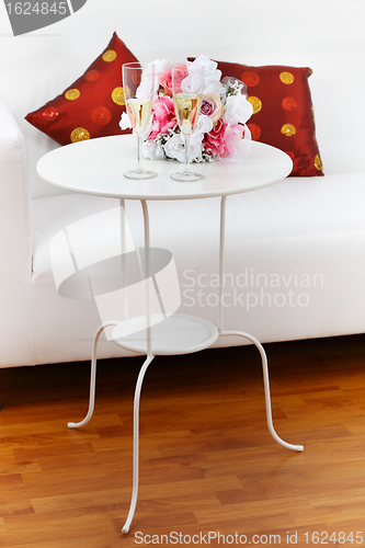 Image of Sparkling wine with bouquet on side table