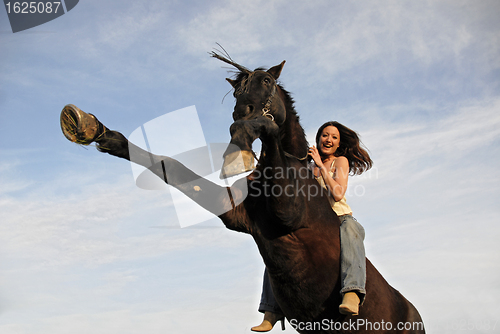 Image of rearing stallion and laughing girl