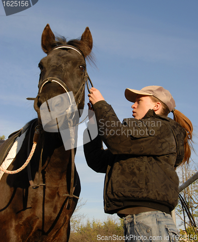 Image of teenager, bridle and horse