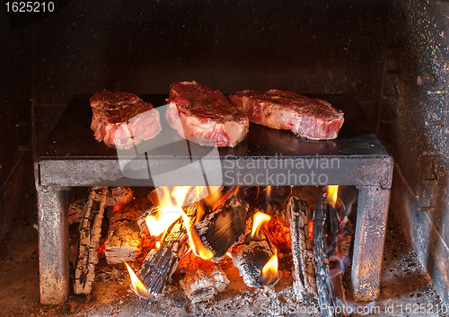 Image of pork steaks preparing on the on a stone plate