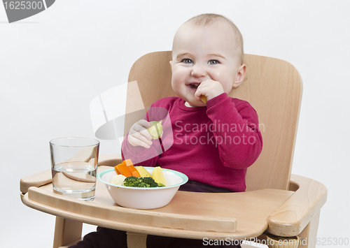 Image of young child eating in high chair