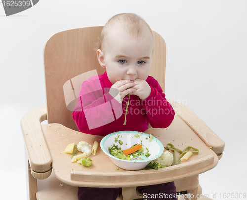 Image of young child eating in high chair