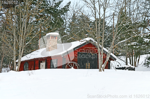 Image of Rustic red wooden barn in snow
