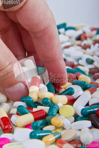 Image of hand grabbing pills