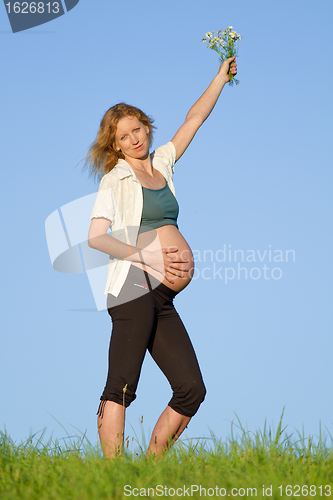 Image of pregnant woman on meadow