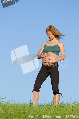 Image of pregnant woman on meadow