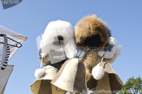 Image of Winter furred hats caps sold at market fair sky 