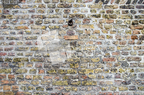 Image of background of retro brick wall metal rusty ring 