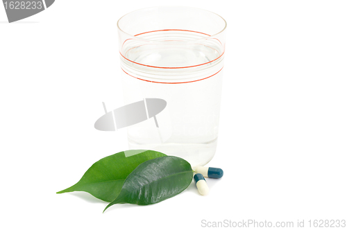 Image of Pills Medicine Capsules and glass with green leaves Bio