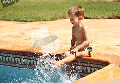 Image of Happy boy having a fun at swimming pool