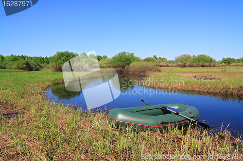 Image of green boat on small river