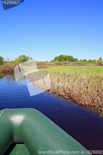 Image of green boat on small river