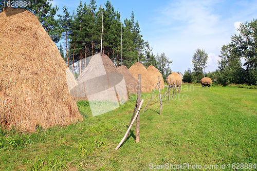 Image of stack hay on green field