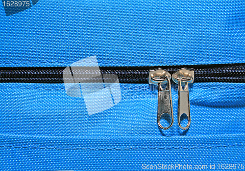 Image of metallic zipper on blue fabrics