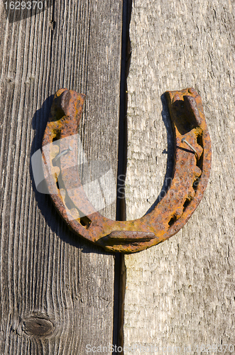 Image of Rusty horseshoe nailed on old wall. Luck sign. 