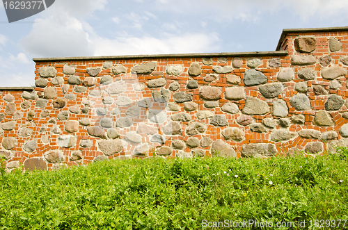 Image of Restored ancient wall made of red brick and stones. 