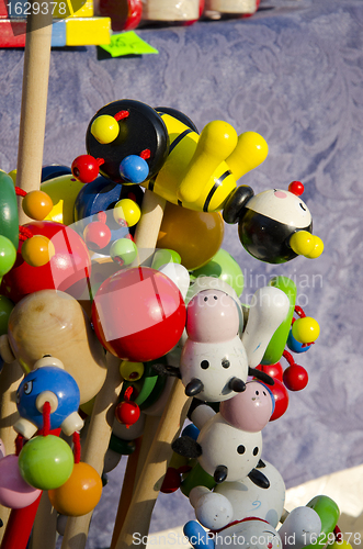 Image of Wooden toys on a stick sold in outdoor fair. 