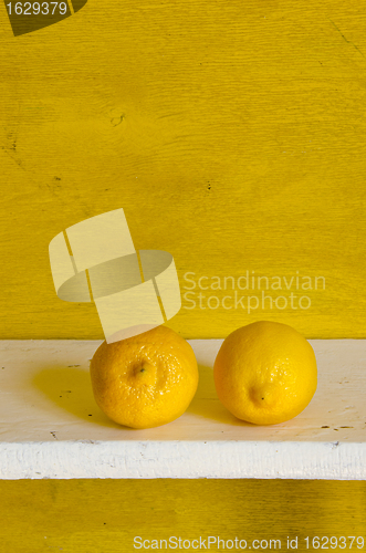 Image of Couple of healthy lemon on shelf. 