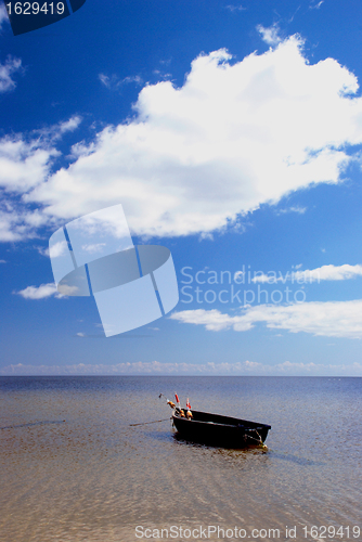 Image of Plastic boat with floats tied at seaside. 