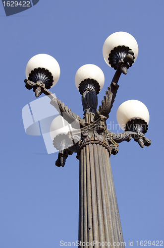 Image of Antique lamp with five large bubbles in park.