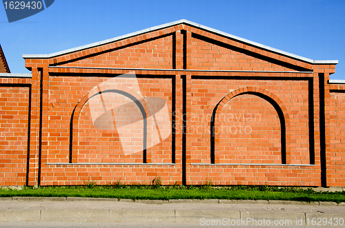 Image of Red brick building wall with decorations. 