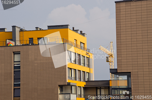 Image of Modern houses and crane between it. Construction. 