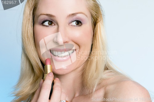 Image of Beauty - happy female applying pink lipstick