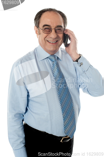 Image of Smiling businessman attending phone call