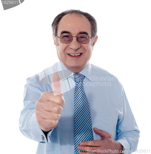 Image of Smiling mature businessman showing thumbs-up