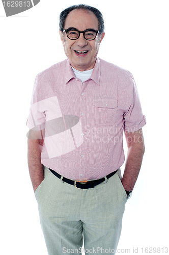 Image of Smiling casual senior man with hands in pocket