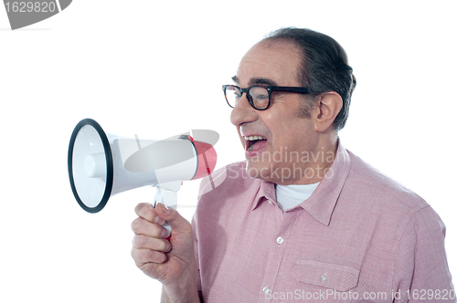 Image of Elder casual man shouting through megaphone