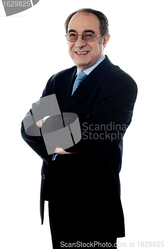 Image of Welldressed company director posing with folded arms