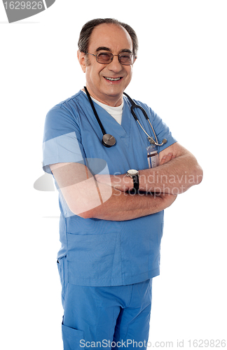 Image of Smiling matured doctor posing with folded arms