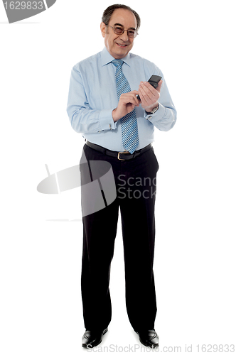 Image of Handsome old corporate man using cellphone