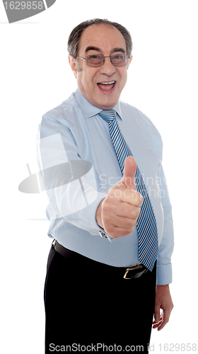 Image of Happy senior manager posing with thumbs-up gesture