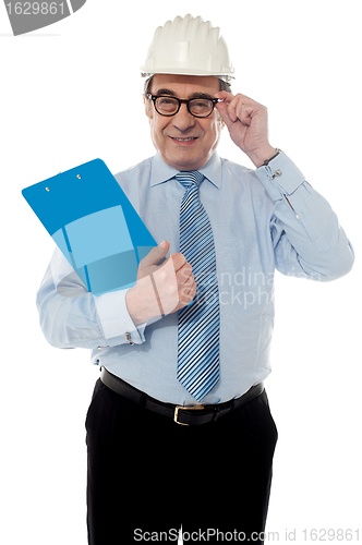 Image of Smiling matured architect holding his eye-wear