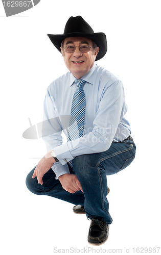 Image of Image of a senior cowboy posing semi seated