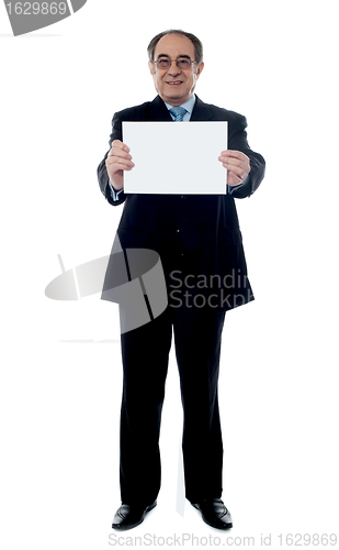 Image of Senior business professional holding blank billboard