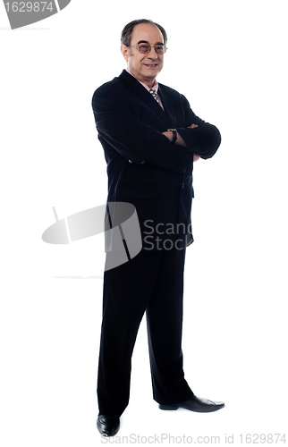 Image of Handsome old manager standing with arms crossed